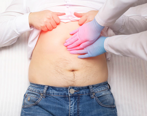 The doctor examines a patient who has abdominal pain. Pancreas inflammation concept, pancreatitis, close-up. The doctor examines a patient who has abdominal pain. Pancreas inflammation concept, pancreatitis, close-up. Inflammation of the gallbladder and duodenum